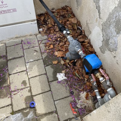 צנרת וכלי עבודה על רצפת אבן עם עלים יבשים