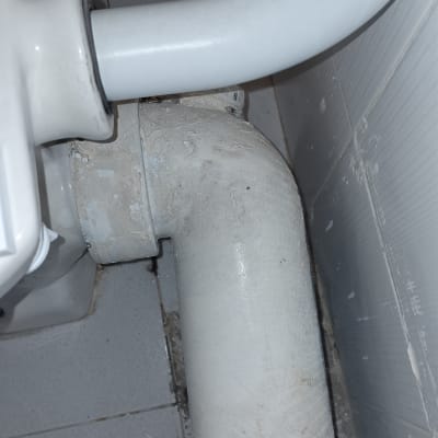 צינור לבן מתחת לכיור בחדר אמבטיה