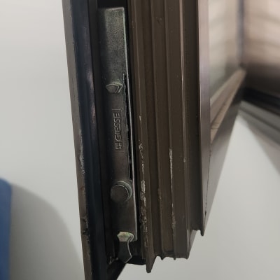 חלק ממנגנון תריס מתכת בחלון