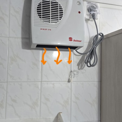 תנור חימום חשמלי מותקן על קיר בחדר אמבטיה