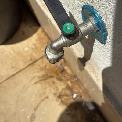 ברז מים מותקן על קיר עם ידית שחורה