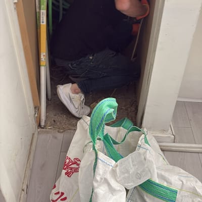 אדם עם כפפות כתומות עובד בארון חשמל