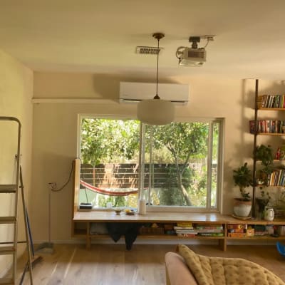 מזגן מותקן על הקיר מעל חלון גדול