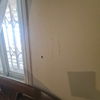 קיר עם חור ליד חלון ומיטה