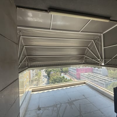 מרפסת עם סוכך מתקפל מעל נוף עירוני