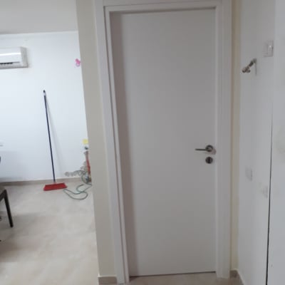 דלת לבנה עם משקוף גבס בקיר פנימי