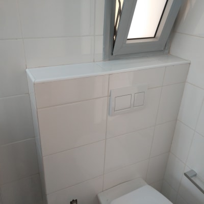 לחצני הדחה כפולים על קיר אריחים לבנים