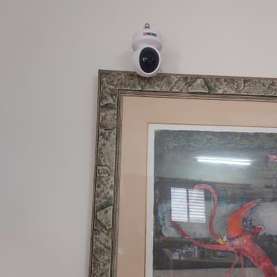 מצלמת אבטחה מותקנת על קיר מעל תמונה