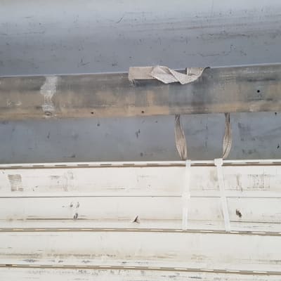 תריסים לבנים עם רצועות קשירה על צינור מתכת