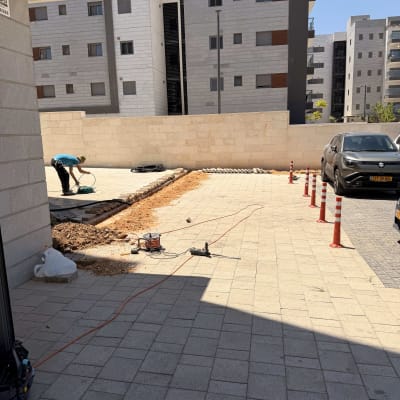 אדם עובד בחוץ ליד בניין עם כלי עבודה