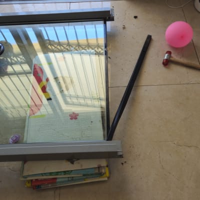 חלון זכוכית שבור עם כלים על הרצפה
