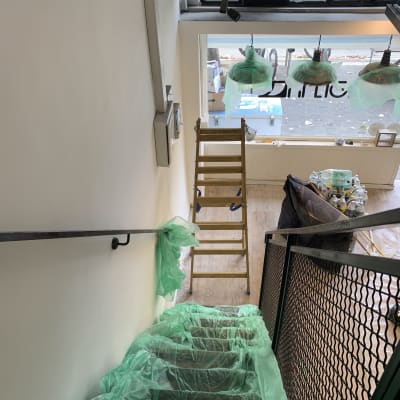 מדרגות מכוסות בניילון ירוק, סולם עץ, מנורות עטופות