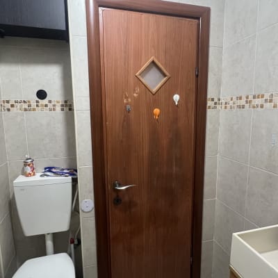 דלת עץ עם חלון יהלום בחדר אמבטיה