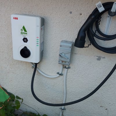 עמדת טעינה לרכב חשמלי עם כבל מחובר לקיר