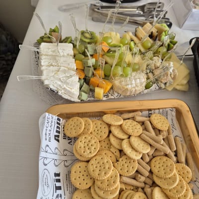 מגש גבינות ופירות עם קרקרים על שולחן קייטרינג