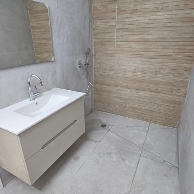 חדר אמבטיה משופץ עם מקלחון וכיור חדש