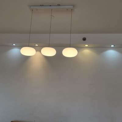 שלושה גופי תאורה תלויים מהתקרה מוארים