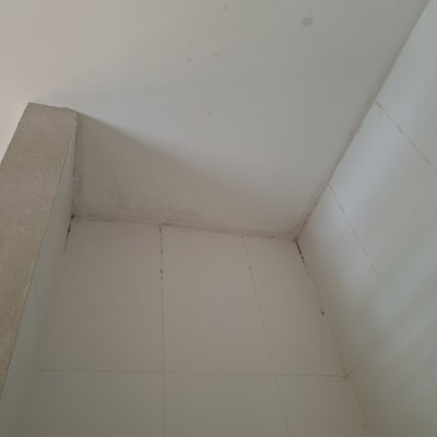 פינת חדר עם אריחים וקיר לבן
