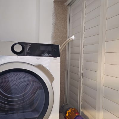 מכונת כביסה עם צינור ניקוז מחובר לקיר