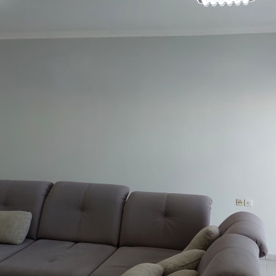 סולם עץ עם כתמי צבע ליד קיר צבוע