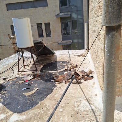 גג עם יריעות איטום קרועות וכלי עבודה