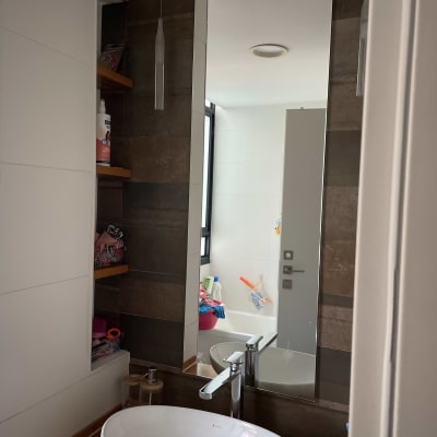 מראה מלבנית תלויה על קיר בחדר אמבטיה