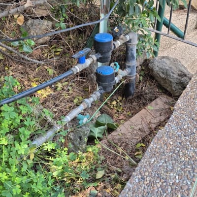 צנרת מים עם ברזים כחולים בגינה