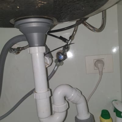 צנרת מתחת לכיור עם חיבורים וכלים לניקוי