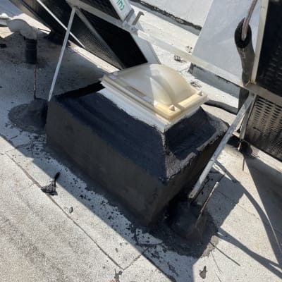 איטום גג עם חומר שחור סביב צינור ופתח