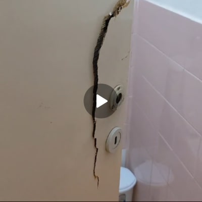 דלת עם סדק גדול ומנעול בחדר אמבטיה