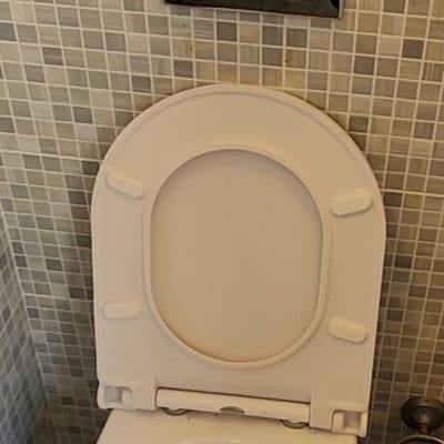 אסלה עם לחצן הדחה על קיר אריחים