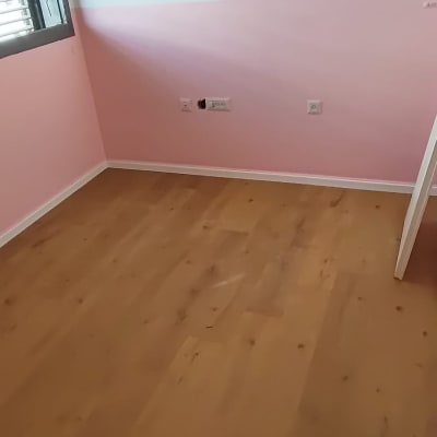 רצפת פרקט בחדר עם קיר ורוד