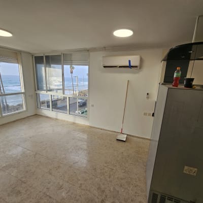 חדר ריק עם חלונות גדולים, מזגן ומטאטא