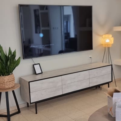 טלוויזיה תלויה על הקיר עם כבלים חשמליים