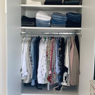 ארון בגדים מסודר עם בגדים מקופלים ותלויים