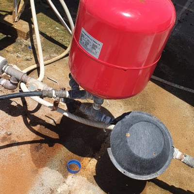 מיכל אדום וצינורות על גג, קשור למערכת סולארית