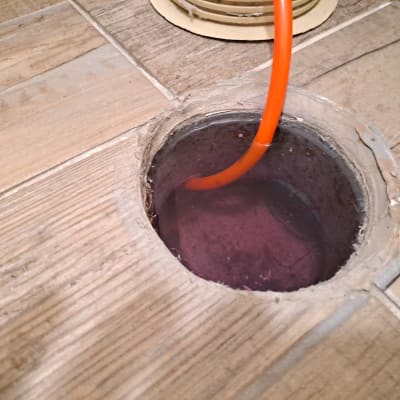 צינור כתום בתוך פתח ניקוז ברצפה