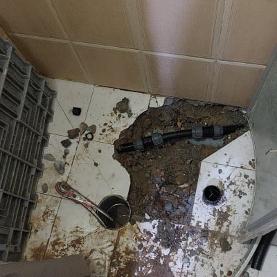 צינור חשוף עם כלי עבודה על רצפה שבורה