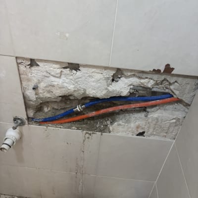 תמונה של קיר פתוח עם צינורות חשופים