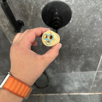 יד מחזיקה חלק פלסטיק עגול מול ברז מקלחת