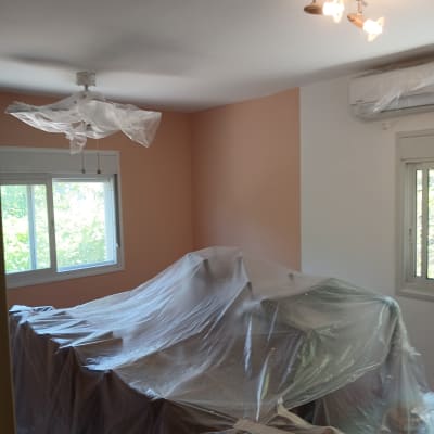חדר עם קירות צבועים, רהיטים מכוסים בניילון