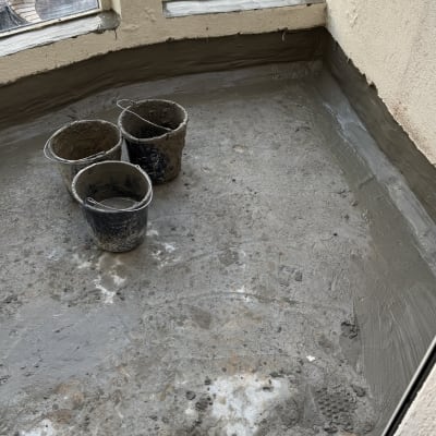 שלושה דליים עם חומר בנייה על רצפת בטון