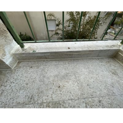 מרפסת עם ריצוף אבן ומעקה ירוק, איטום בפינות