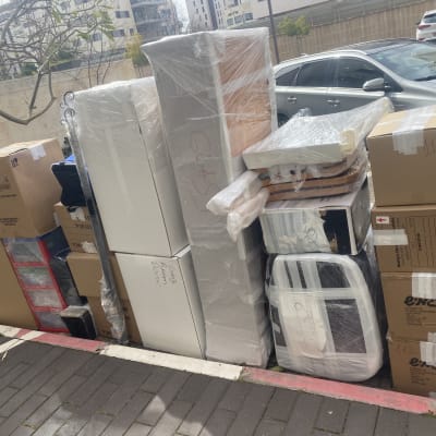 ערימת קרטונים ואריזות עטופות בניילון למעבר דירה