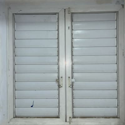 חלון עם תריסים סגורים בצבע לבן