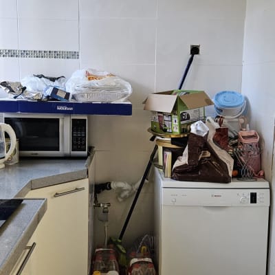 מטבח עם מיקרוגל, מדיח כלים ואריזות על השיש