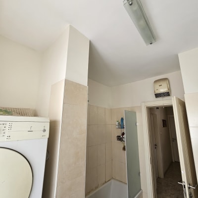 חדר אמבטיה עם אריחים, אמבטיה ודלת פתוחה