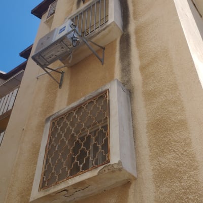 מסגרת מתכת על חלון בניין עם מזגנים