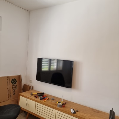 כלי עבודה על שולחן עץ ליד טלוויזיה