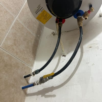 תחתית דוד חשמל תלוי וחיבורי צנרת המים בקיר פנימי